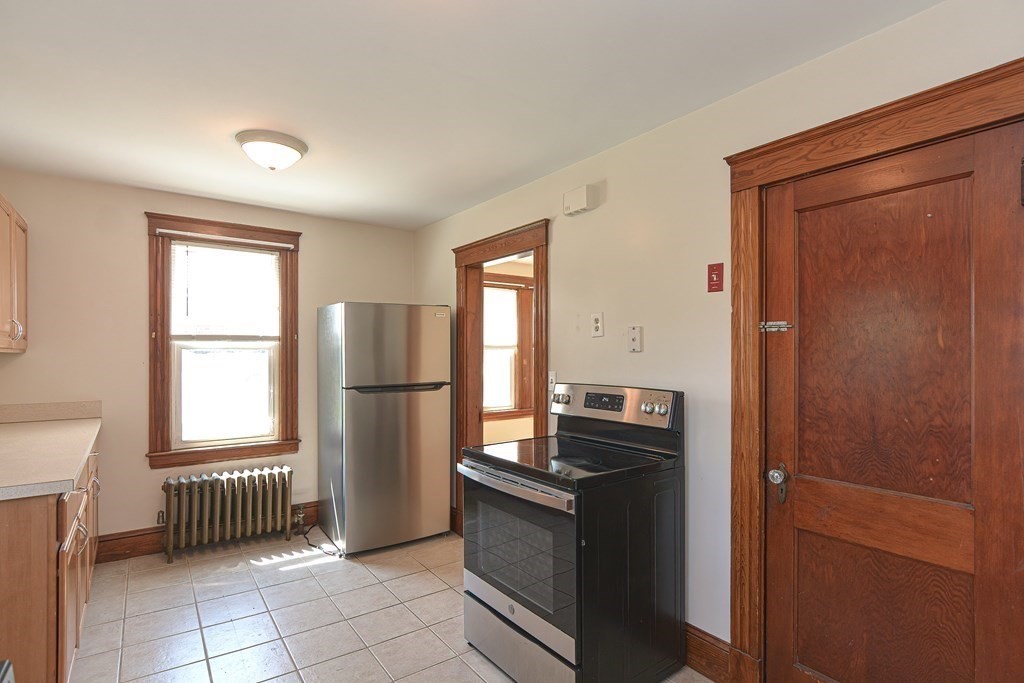 228 Pond Street Natick, MA 01760 - Photo 16 of 36 a kitchen with a refrigerator and a stove top oven