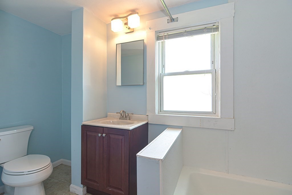 228 Pond Street Natick, MA 01760 - Photo 27 of 36 a bathroom with a toilet a sink a vanity and mirror