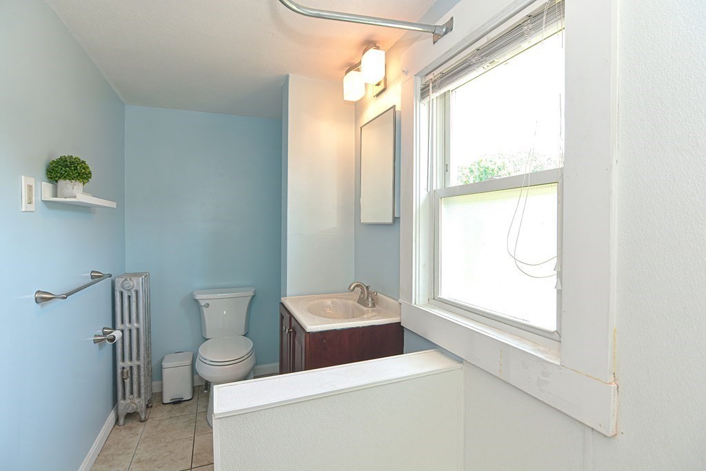 228 Pond Street Natick, MA 01760 - Photo 28 of 36 a bathroom with a toilet a sink and a window