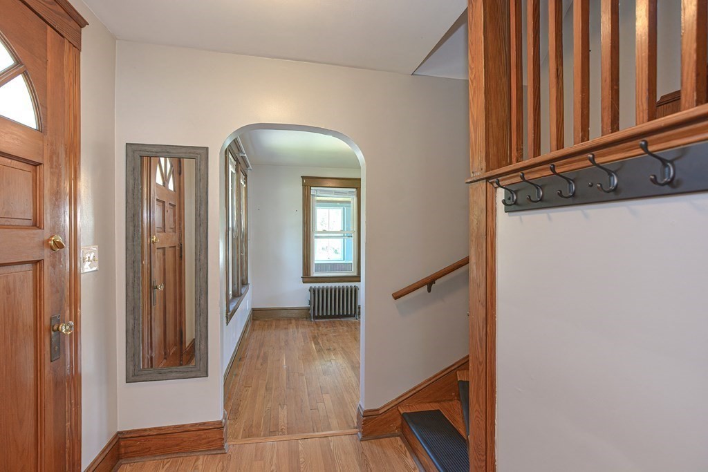 228 Pond Street Natick, MA 01760 - Photo 5 of 36 a view of a hallway with entryway wooden floor and stairs