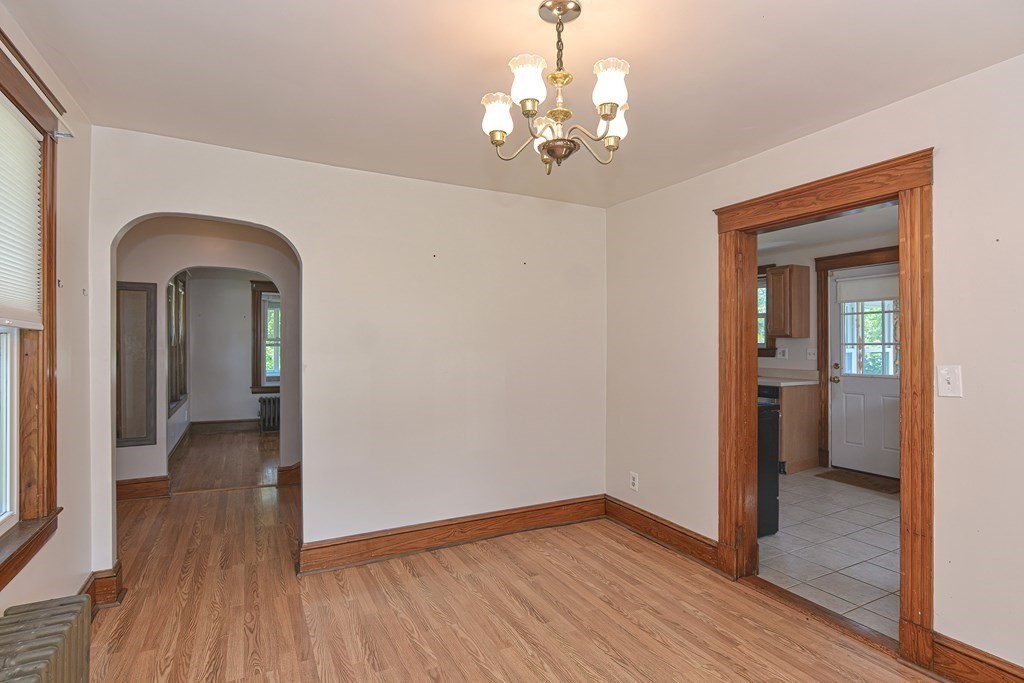228 Pond Street Natick, MA 01760 - Photo 10 of 36 a view of a room with wooden floor staircase and a kitchen