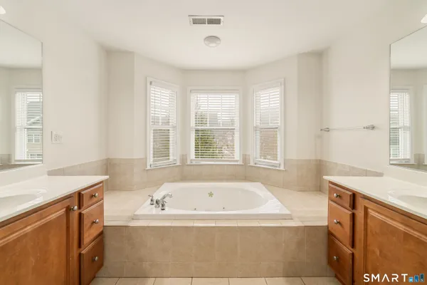 a bathroom with a tub sink and mirror