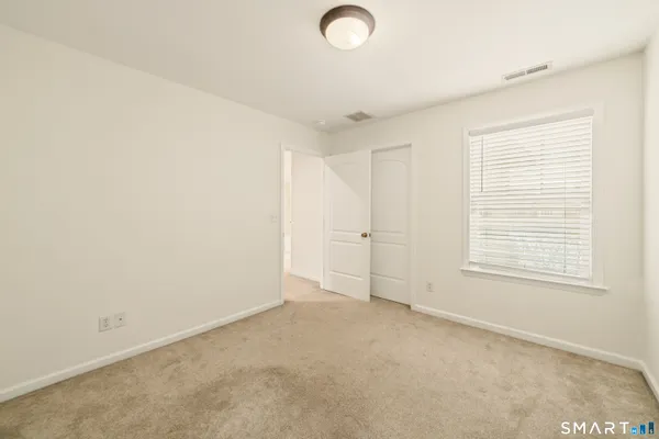 a view of an empty room with a fireplace and a window