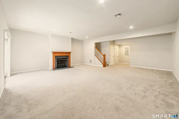 an empty room with a fireplace and entryway
