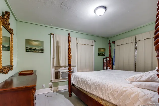 a bedroom with a bed next to a window