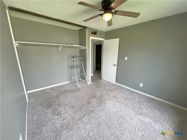 a view of an empty room with a ceiling fan