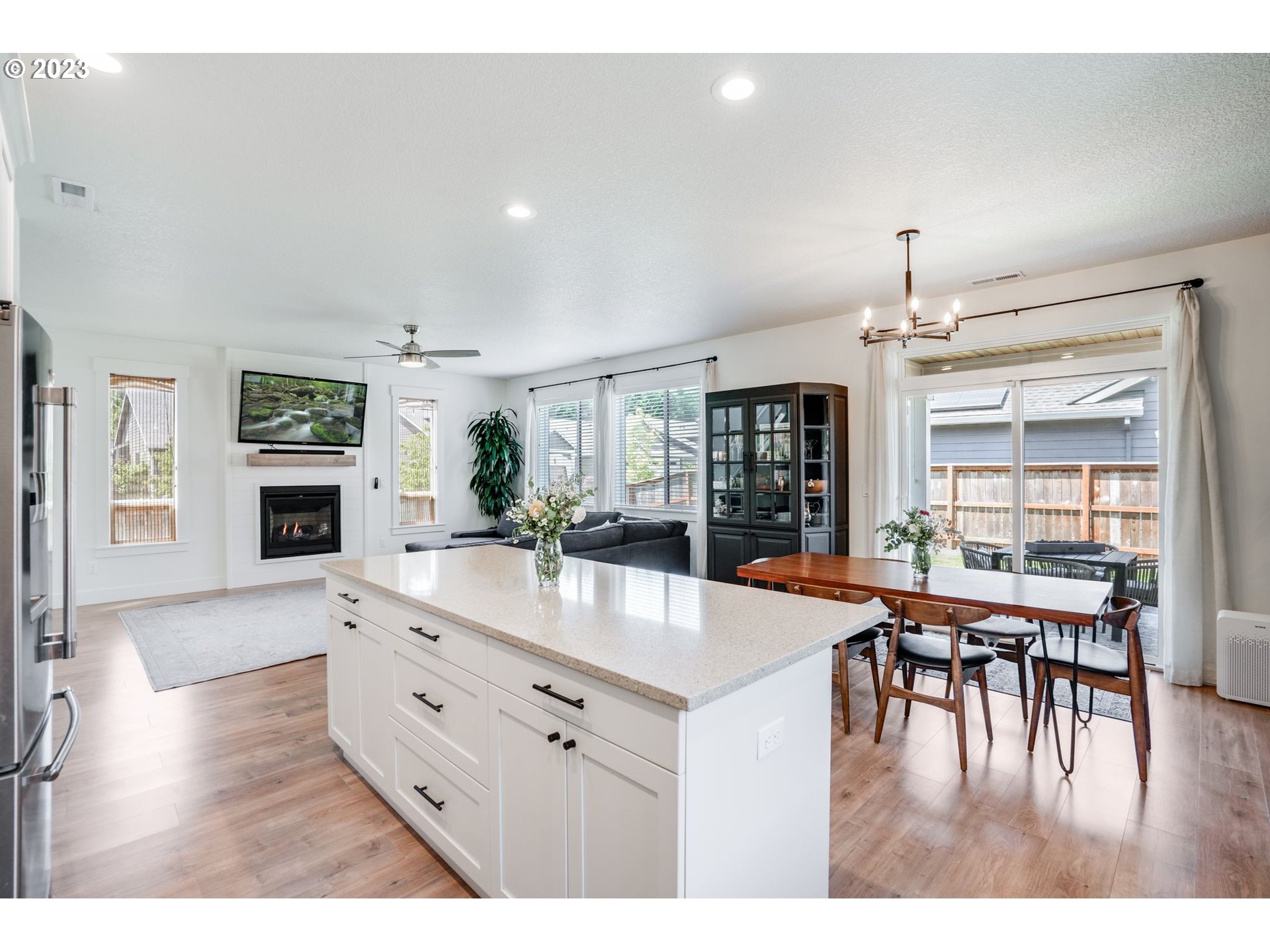 2889 4th Street Hubbard, OR 97032 - Photo 8 of 37 a view of a dining room and livingroom with furniture wooden floor a chandelier