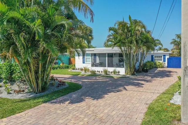 a front view of a house with a yard and potted plants