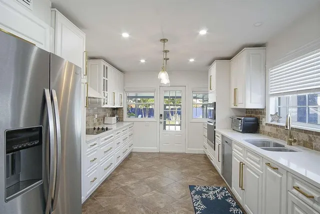 a kitchen with stainless steel appliances a refrigerator sink and cabinets