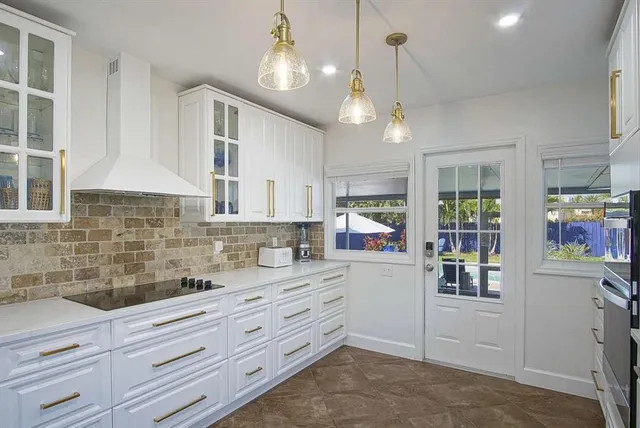 a kitchen with granite countertop cabinets a sink a window and stainless steel appliances