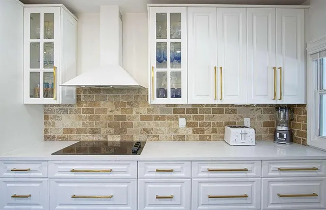 a kitchen with stainless steel appliances white cabinets and a window