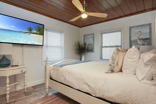 a bedroom with a bed and wooden floor