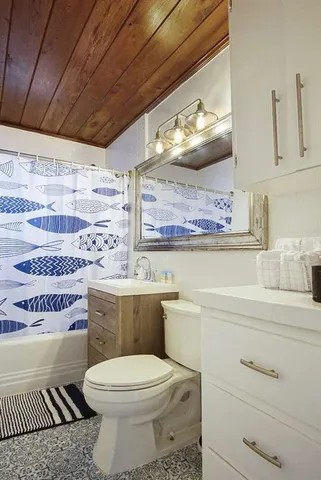 a bathroom with a sink a toilet and a shower curtain