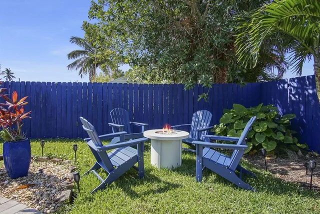 a view of a patio with couches table and chairs under an umbrella