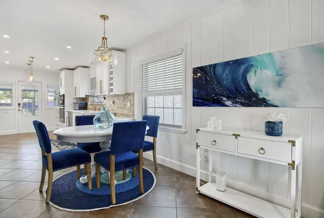 a living room with furniture a dining table and a chandelier