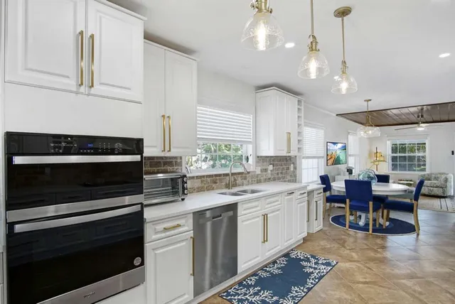 a kitchen with a stove cabinets and chairs