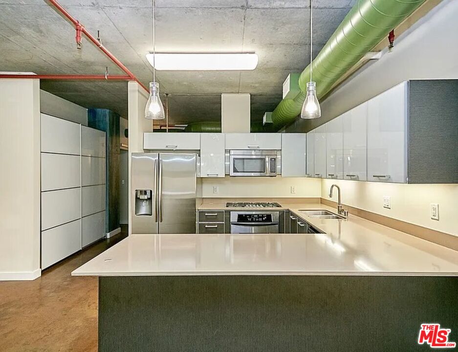 645 West 9th Street, Unit 240 Los Angeles, CA 90015 - Photo 1 of 25 a kitchen with stainless steel appliances a sink a stove a microwave a sink and cabinets