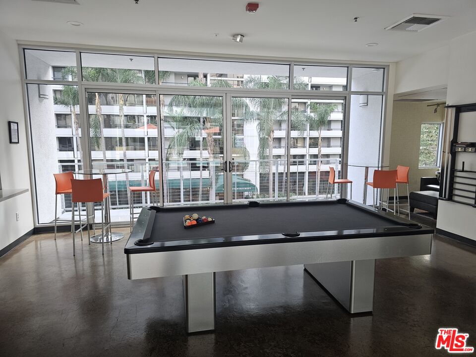645 West 9th Street, Unit 240 Los Angeles, CA 90015 - Photo 16 of 25 a room with wooden floor table and chairs