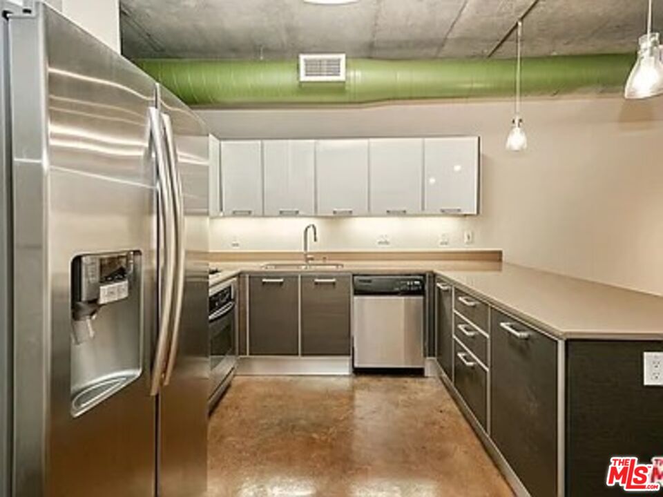 645 West 9th Street, Unit 240 Los Angeles, CA 90015 - Photo 6 of 25 a kitchen with stainless steel appliances granite countertop a sink a stove and a refrigerator