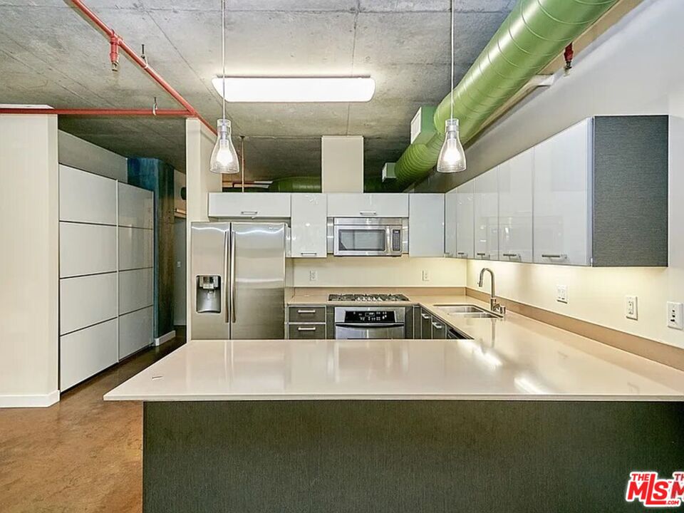 645 West 9th Street, Unit 240 Los Angeles, CA 90015 - Photo 7 of 25 a kitchen with stainless steel appliances a sink a stove a microwave a sink and cabinets