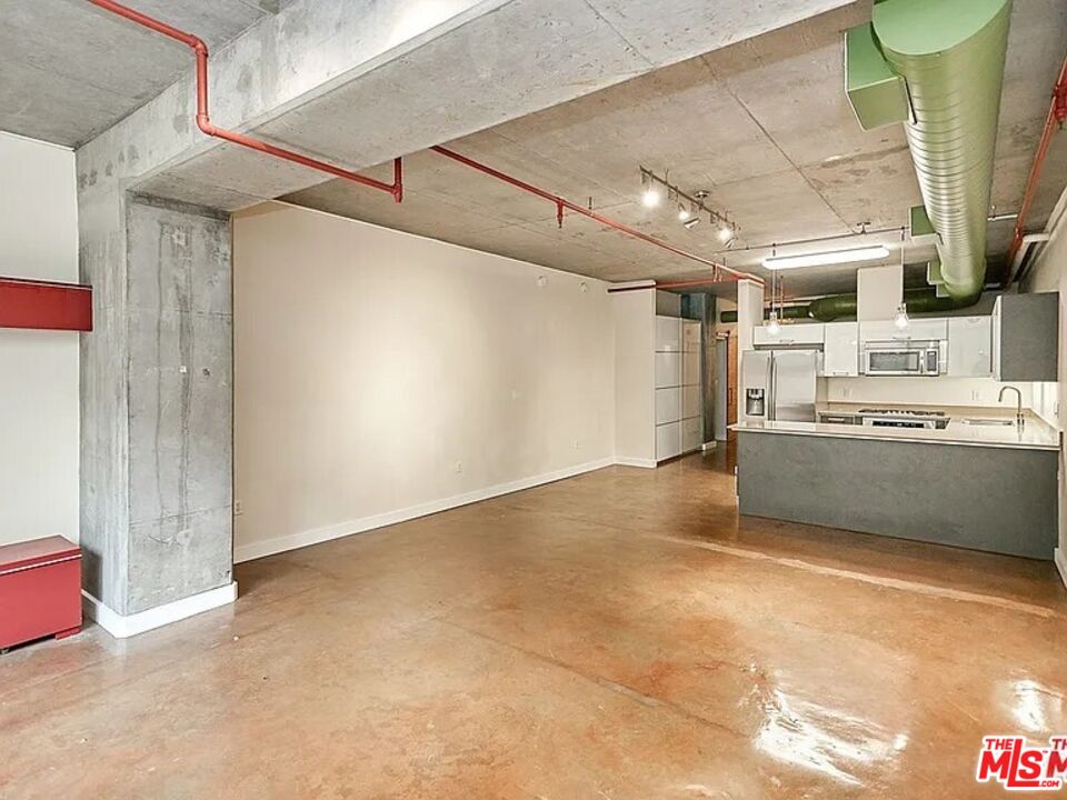 645 West 9th Street, Unit 240 Los Angeles, CA 90015 - Photo 9 of 25 a view of a kitchen with a sink and dishwasher a refrigerator with wooden floor