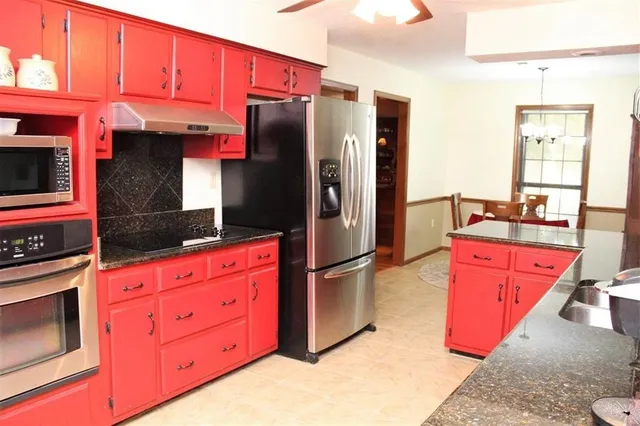 a kitchen with stainless steel appliances granite countertop a refrigerator and a stove