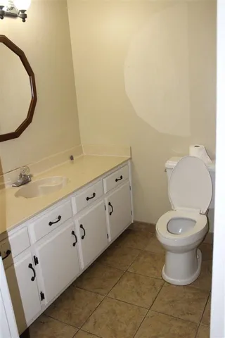 a bathroom with a granite countertop toilet and a sink