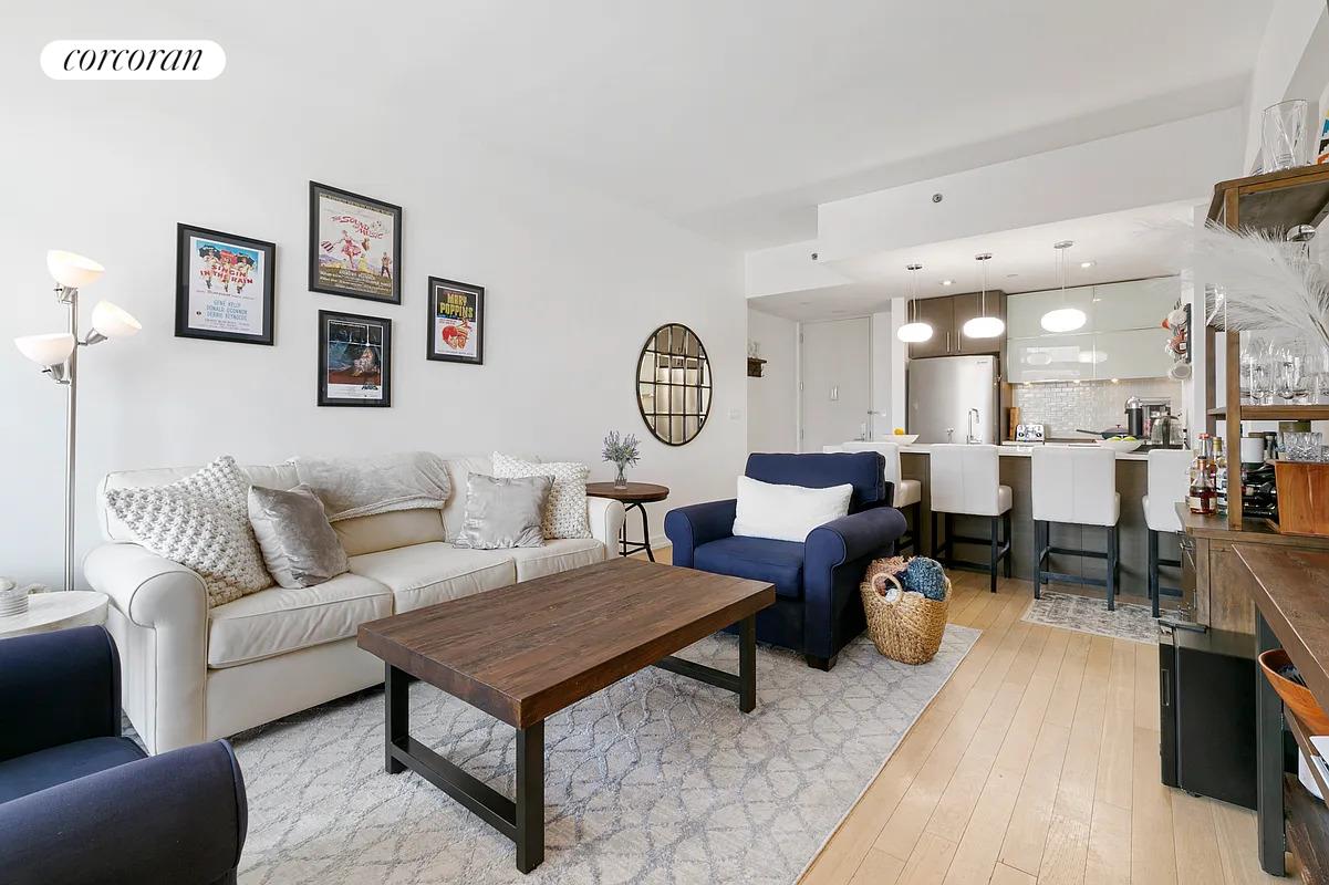 21-45 44th Drive, Unit 6B Queens, NY 11101 - Photo 2 of 14 a living room with furniture a rug and a table