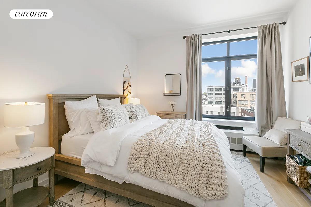 21-45 44th Drive, Unit 6B Queens, NY 11101 - Photo 6 of 14 a bedroom with a bed and a large window