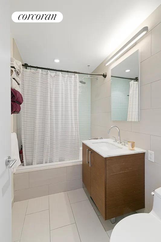21-45 44th Drive, Unit 6B Queens, NY 11101 - Photo 7 of 14 a bathroom with a sink a toilet and shower