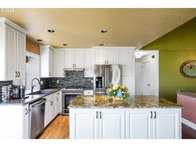 a kitchen with kitchen island a counter top space a sink stove and refrigerator