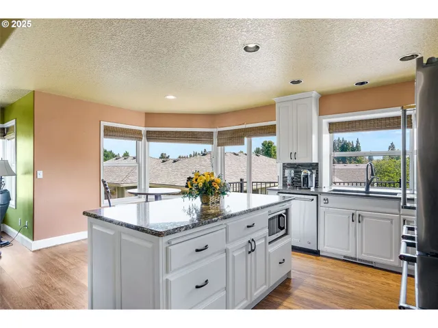 a kitchen with granite countertop a sink and cabinets