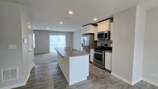a view of a kitchen with refrigerator and a sink