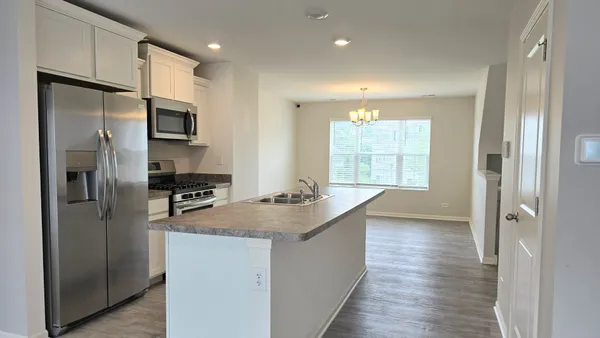 a kitchen with kitchen island a sink appliances and cabinets