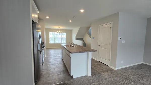 a kitchen with stainless steel appliances kitchen island granite countertop a stove and a refrigerator