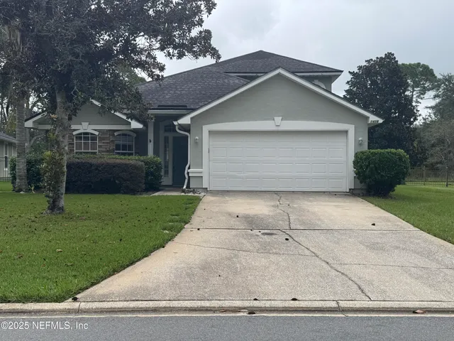 a front view of house with yard and garage