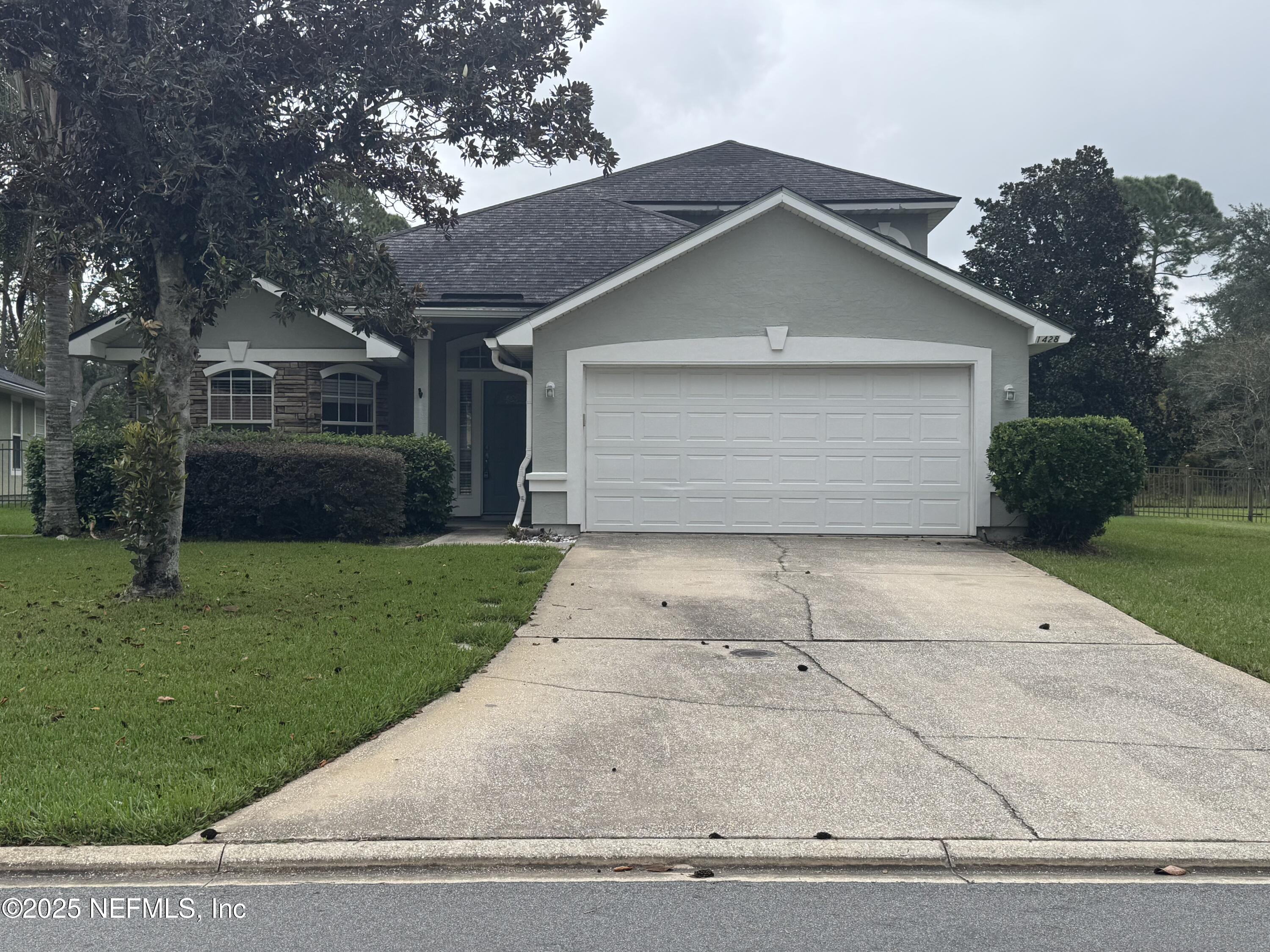 a front view of house with yard and garage