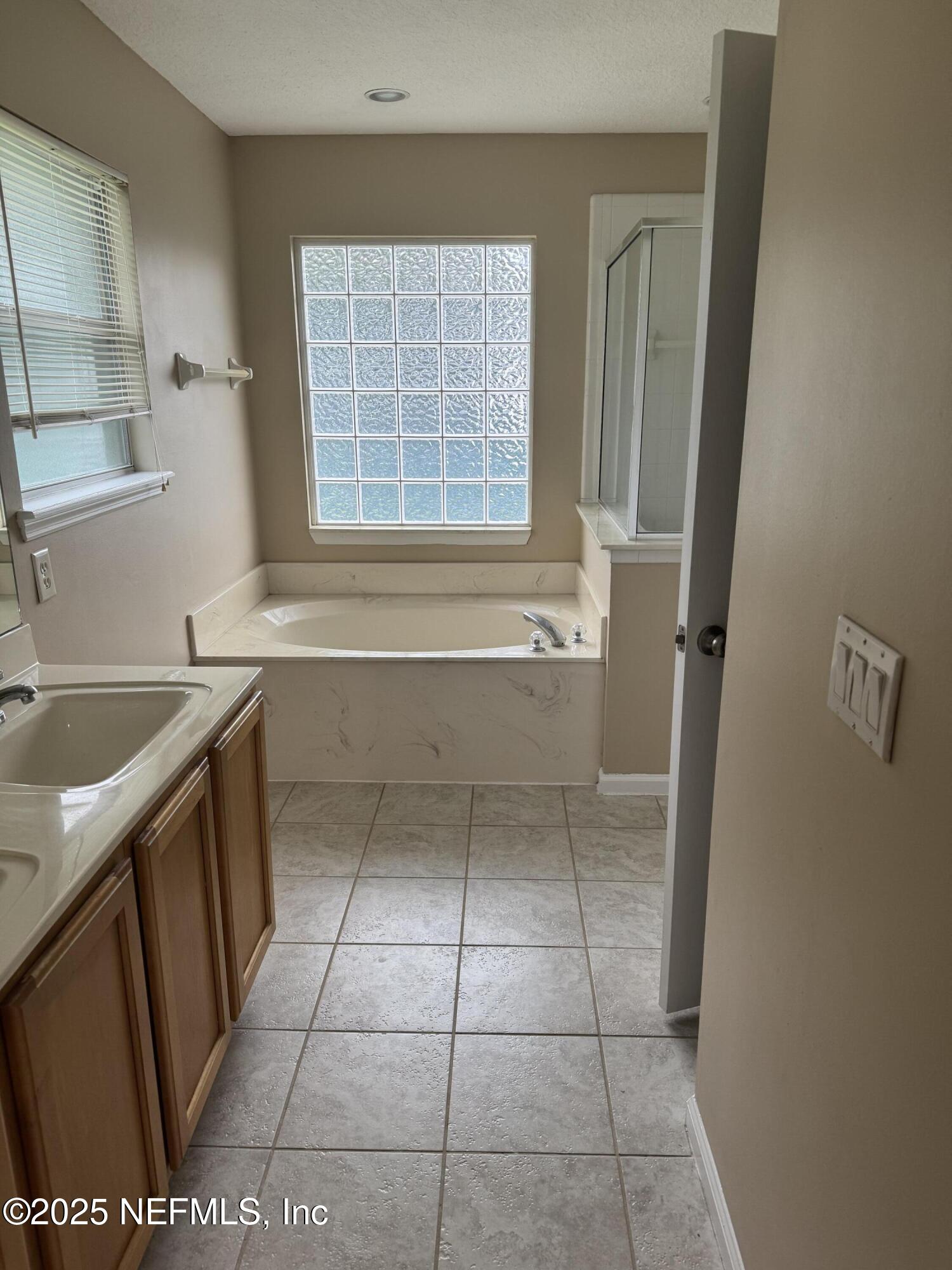 1428 Tintern Lane St. Augustine, FL 32092 - Photo 11 of 15 a bathroom with a granite countertop sink a toilet and a bathtub