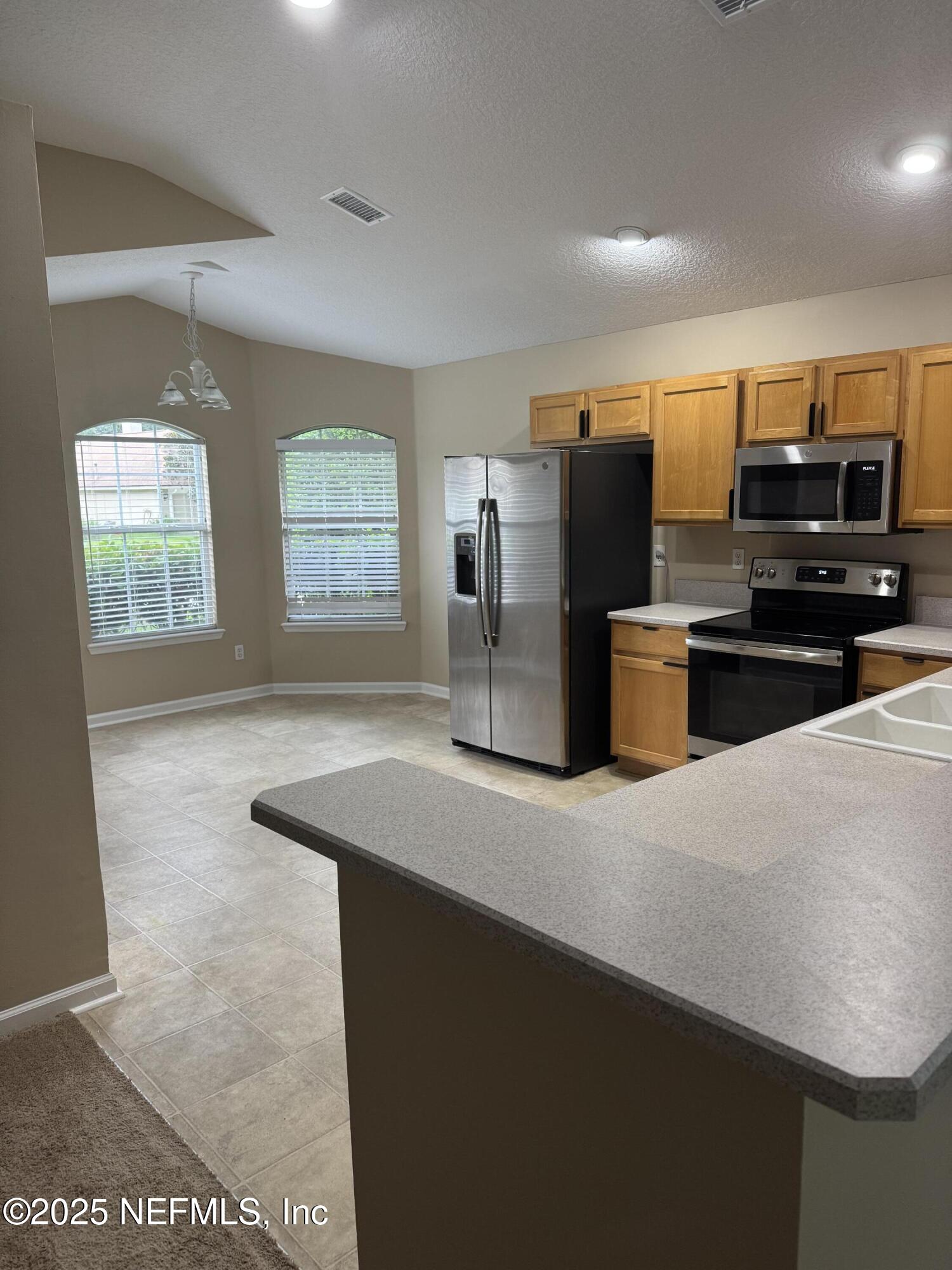 1428 Tintern Lane St. Augustine, FL 32092 - Photo 6 of 15 a kitchen with refrigerator and microwave