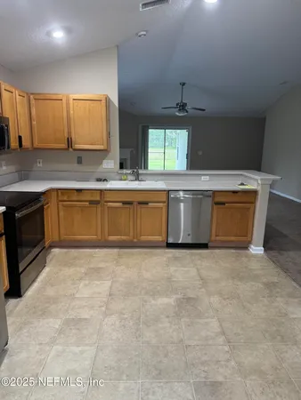 a large kitchen with kitchen island a sink stainless steel appliances and cabinets