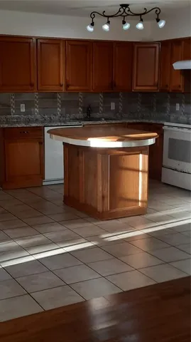 a view of an empty room with a chandelier fan