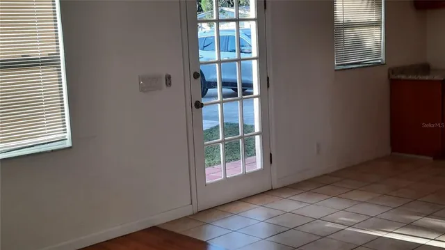 a view of a room with wooden floor a ceiling fan and windows