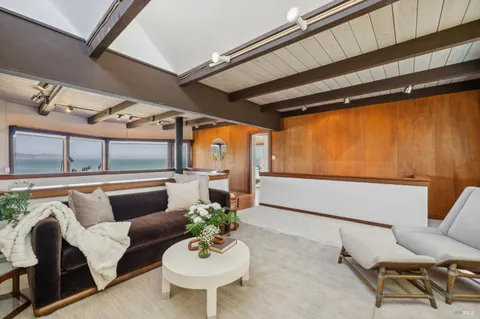 a bedroom with a large bed and wooden floor