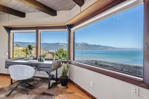 a white vase with flowers sitting on a table
