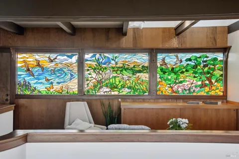 a view of a balcony with chairs and wooden floor