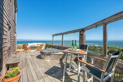 a view of a balcony with chairs and wooden floor