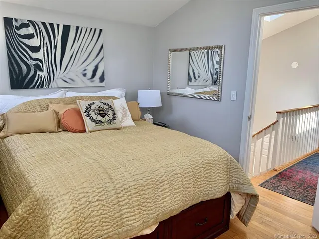 a bedroom with a bed and a painting on the wall