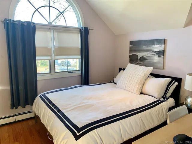 a bed sitting in a bedroom next to a window