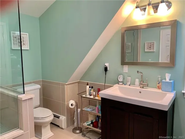 a bathroom with a sink a toilet and mirror
