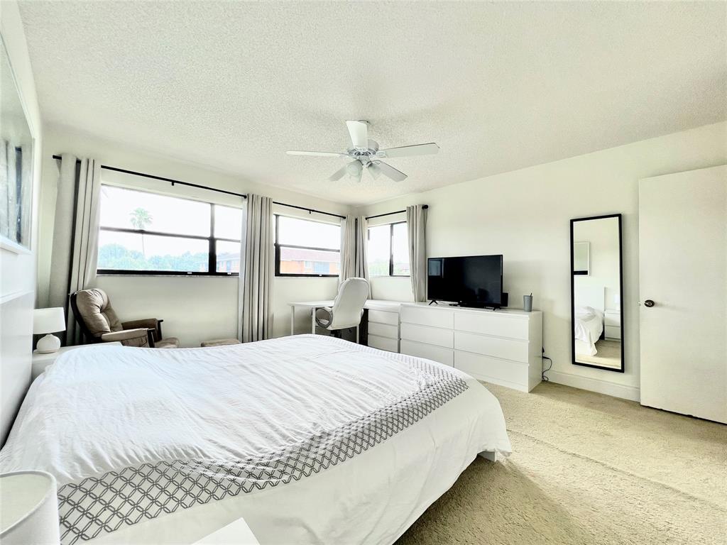 7750 Northwest 79th Avenue, Unit H5 Tamarac, FL 33321 - Photo 17 of 28 a bedroom with a large bed and a flat screen tv